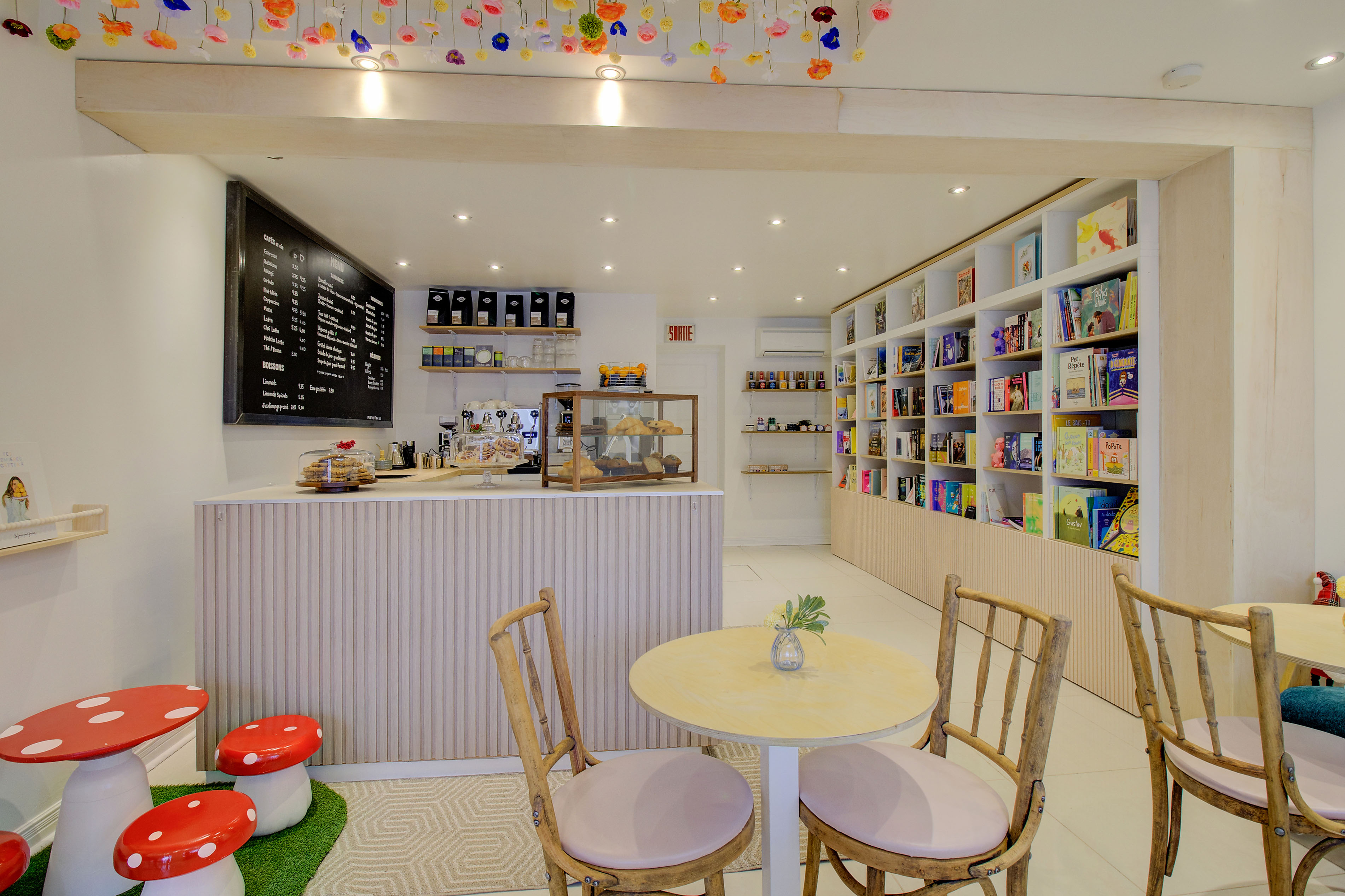 Un café librairie chaleureux avec des fleurs au plafond
