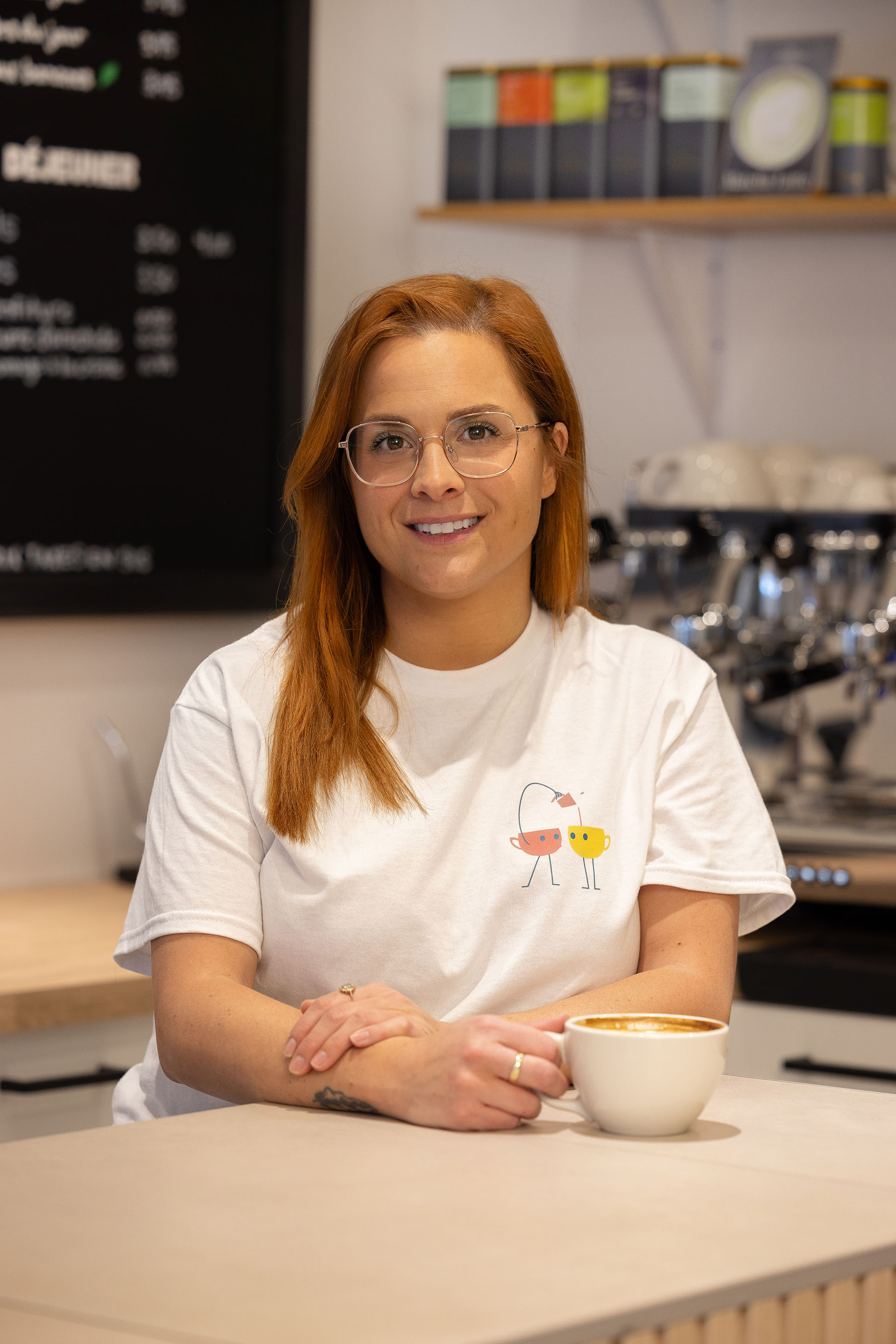 Une barista avec un café latte dans un café de quartier